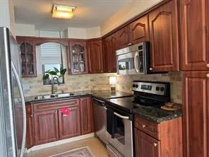 a kitchen with stainless steel appliances granite countertop a sink stove and cabinets