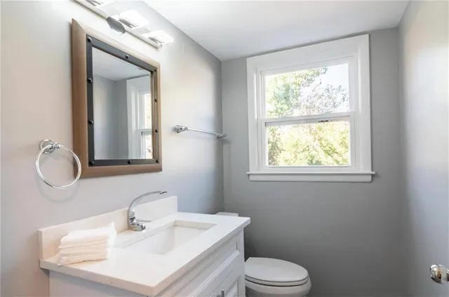 a bathroom with a sink toilet and mirror