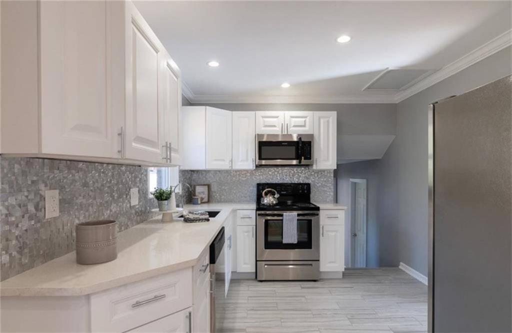 3022 Trafalgar Way, Unit 3022 Atlanta, GA 30341 - Photo 4 of 20 a kitchen with stainless steel appliances granite countertop a sink stove and microwave
