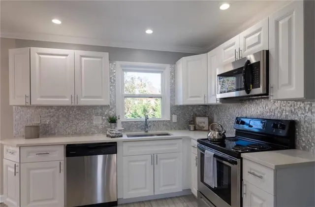 a kitchen with stainless steel appliances granite countertop white cabinets granite counter tops and a window