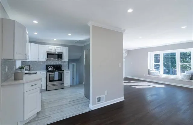 a kitchen with stainless steel appliances granite countertop a refrigerator oven a sink dishwasher and a stove with wooden floor