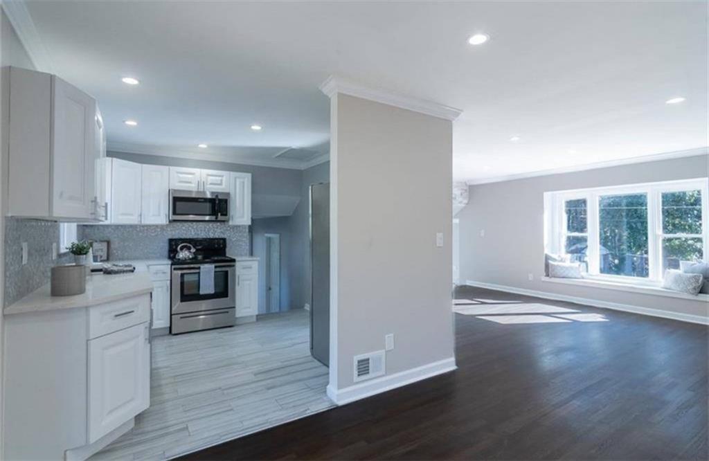 3022 Trafalgar Way, Unit 3022 Atlanta, GA 30341 - Photo 7 of 20 a kitchen with stainless steel appliances granite countertop a refrigerator oven a sink dishwasher and a stove with wooden floor