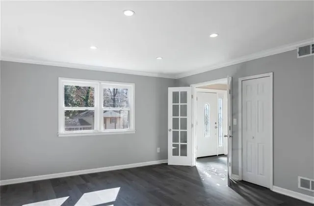 an empty room with wooden floor and windows