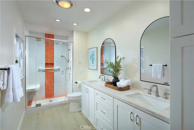 a bathroom with a double vanity sink toilet and shower