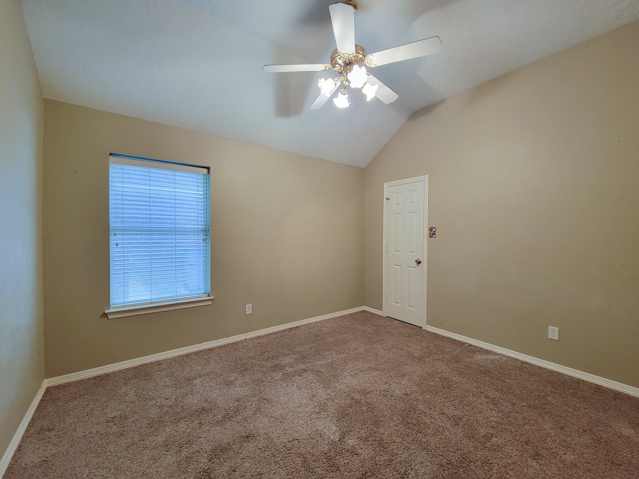 18511 Falcon Crest Drive Humble, TX 77346 - Photo 29 of 35 an empty room with a chandelier fan and windows