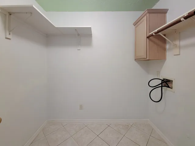 an empty room with wooden floor fireplace and windows