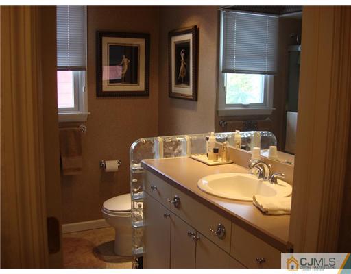16 Fishel Road Edison, NJ 08820 - Photo 21 of 25 a bathroom with a granite countertop toilet a sink and mirror