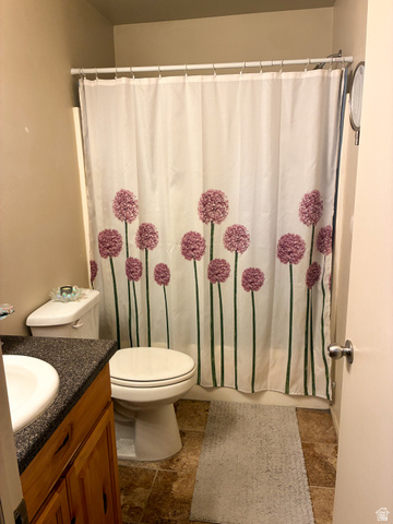 297 West Bricker Road Draper, UT 84020 - Photo 16 of 25 Full bathroom with vanity, shower / tub combo with curtain, and stone finish flooring
