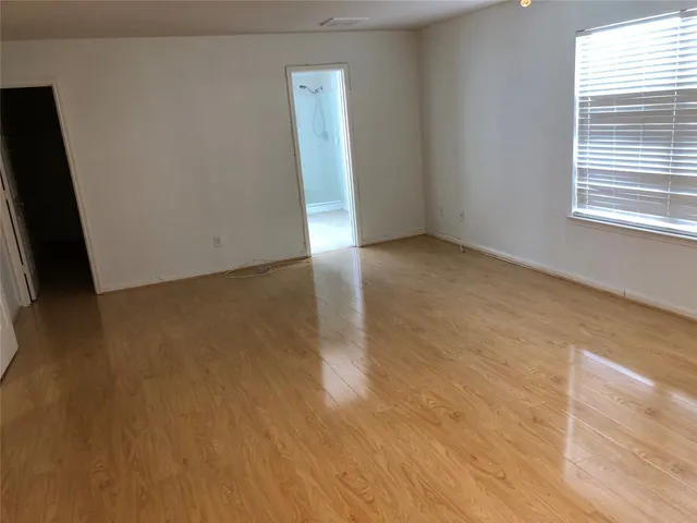 a view of a room with wooden floor and windows