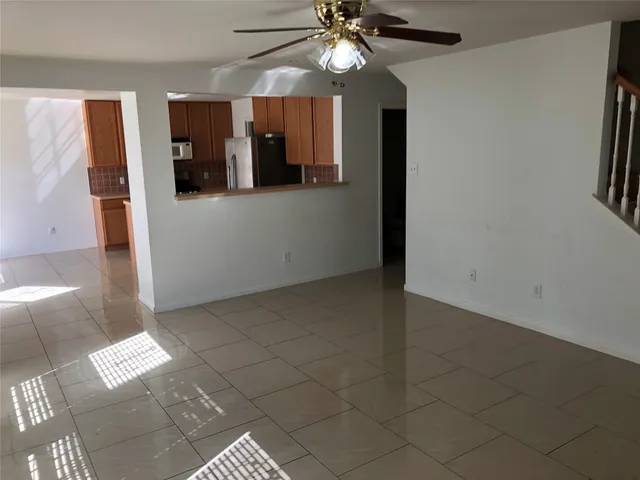 en empty room with windows and ceiling fan