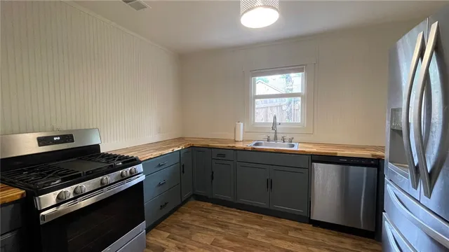 a kitchen with stainless steel appliances granite countertop a sink stove and refrigerator