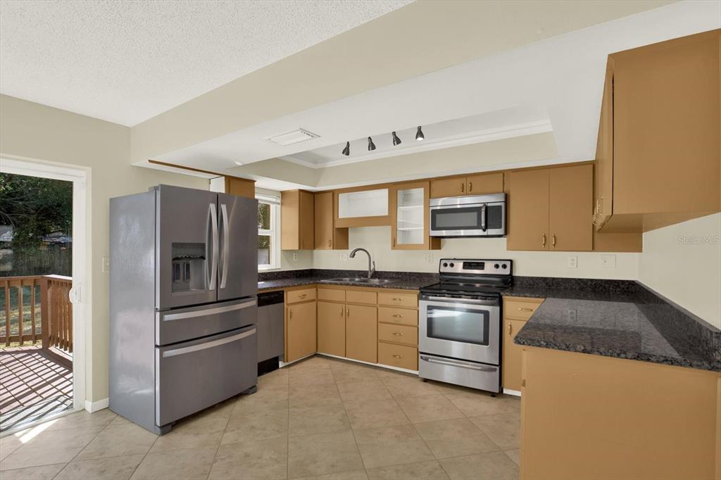 3485 Pine Street Dunedin, FL 34698 - Photo 3 of 22 a kitchen with stainless steel appliances granite countertop a stove a sink and a refrigerator