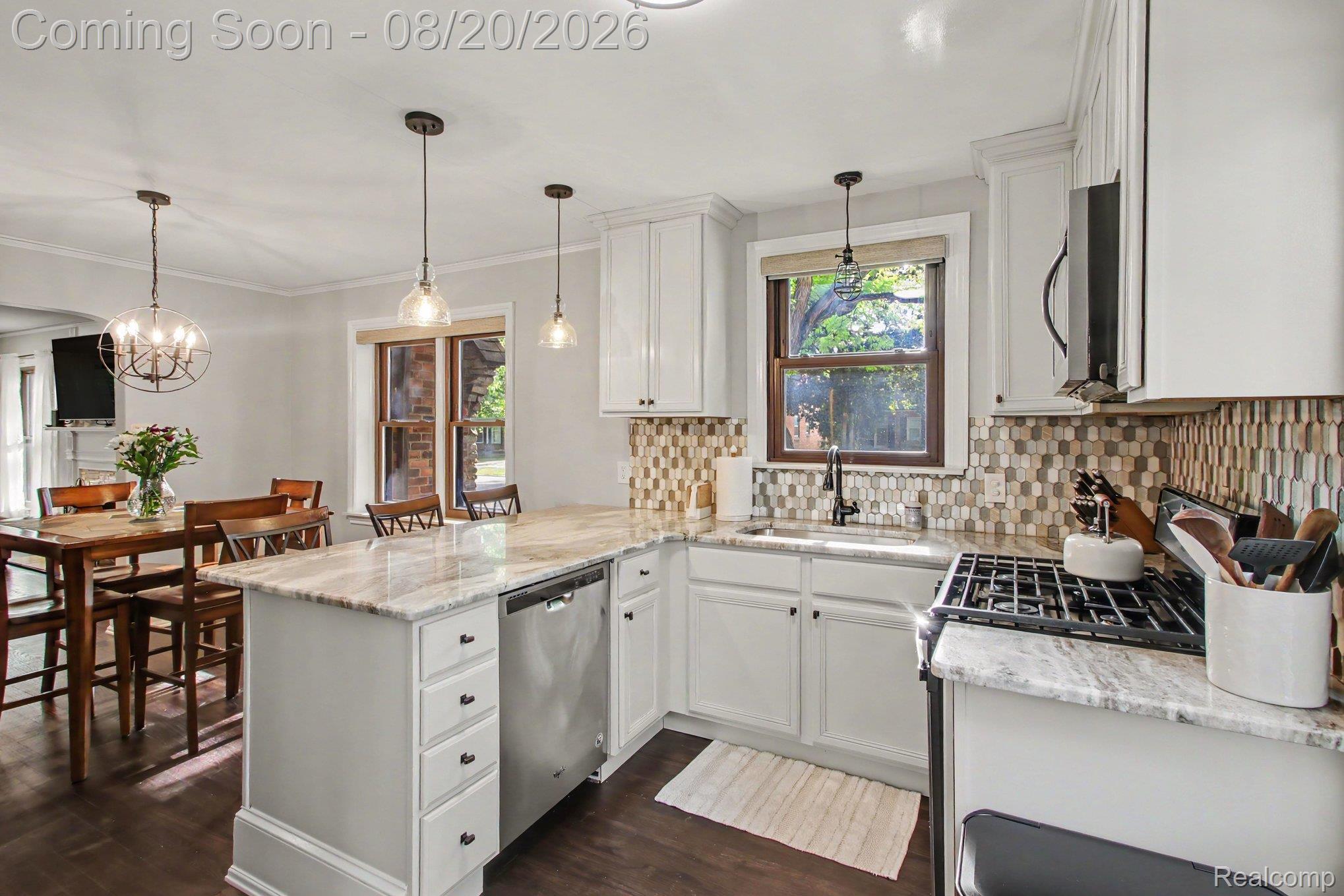4098 Wakefield Road Berkley, MI 48072 - Photo 14 of 49 White cabinetry with dark hardware, stainless steel appliances, patterned tile backsplash, and light-toned countertops