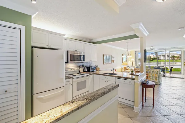 a kitchen with granite countertop a sink stainless steel appliances and cabinets