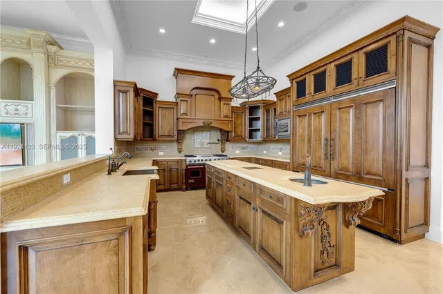a large kitchen with stainless steel appliances granite countertop a sink a stove and a refrigerator