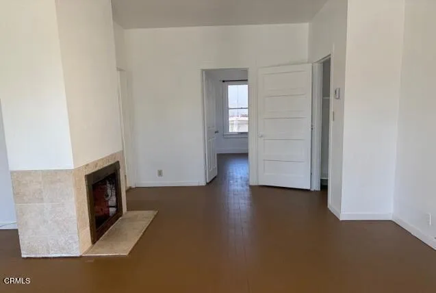 a view of empty room with wooden floor and fireplace