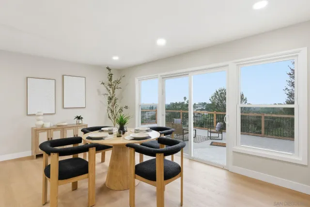 a living room with stainless steel appliances kitchen island granite countertop a sink and a large window
