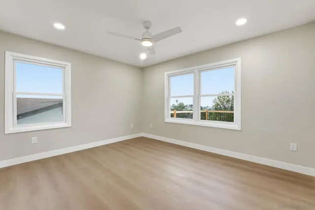 an empty room with a window and ceiling fan