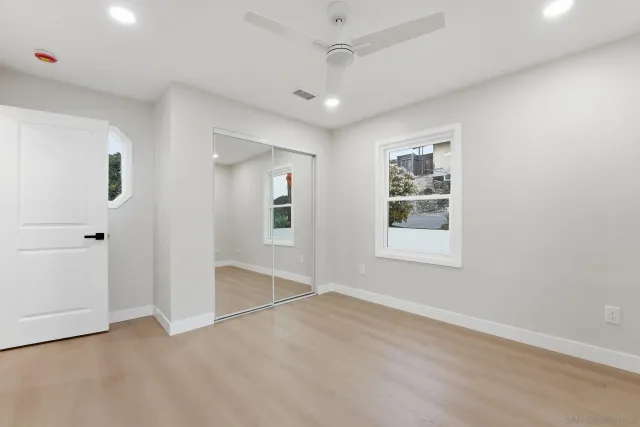 an empty room with wooden floor and a window