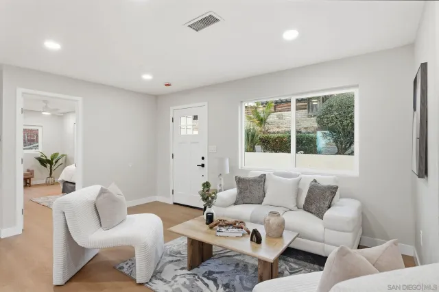 a living room with furniture floor to ceiling window and wooden floor