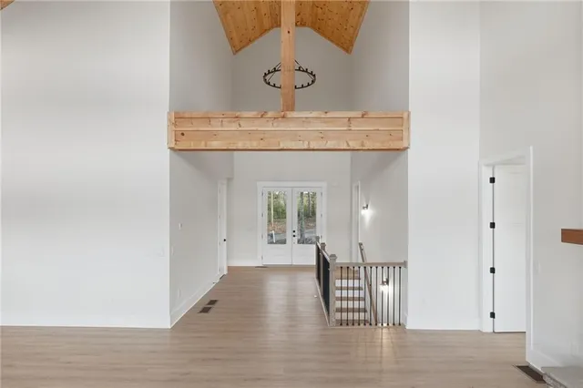 a view of a hallway with wooden floor and windows