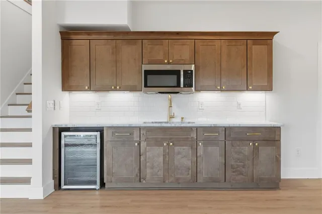 a kitchen with granite countertop a stove a sink and a refrigerator
