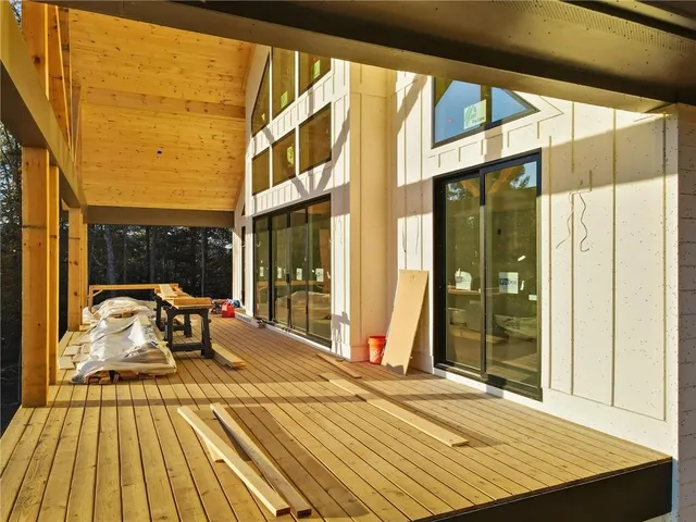 a balcony with wooden floor table and chairs