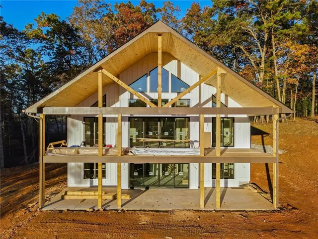a view of a white house with large windows and a small yard