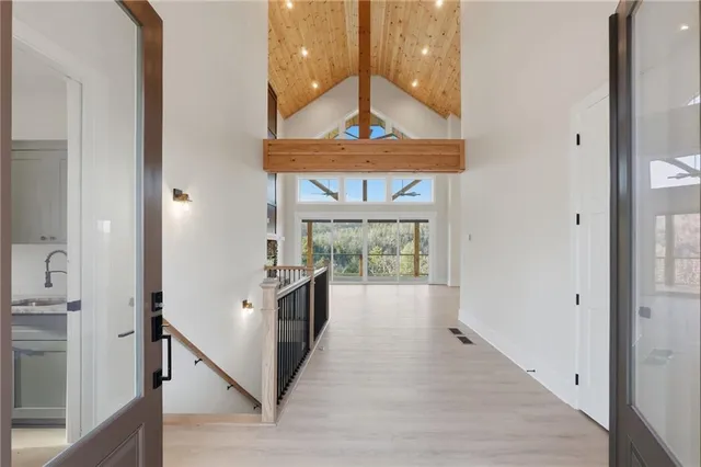 a view of a hallway with wooden floor and chandelier