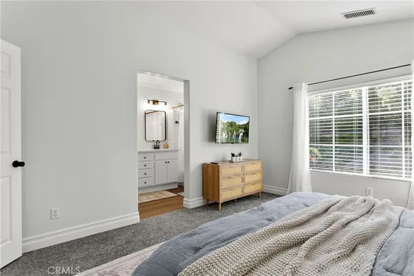 a bedroom with a bed mirror and window