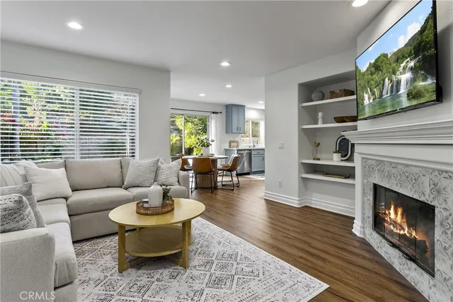 a living room with furniture a fireplace and a flat screen tv