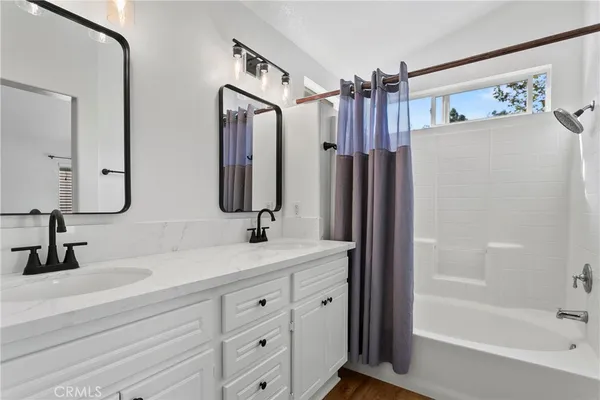 a bathroom with a double vanity sink mirror and shower