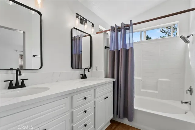 a bathroom with a double vanity sink mirror and shower