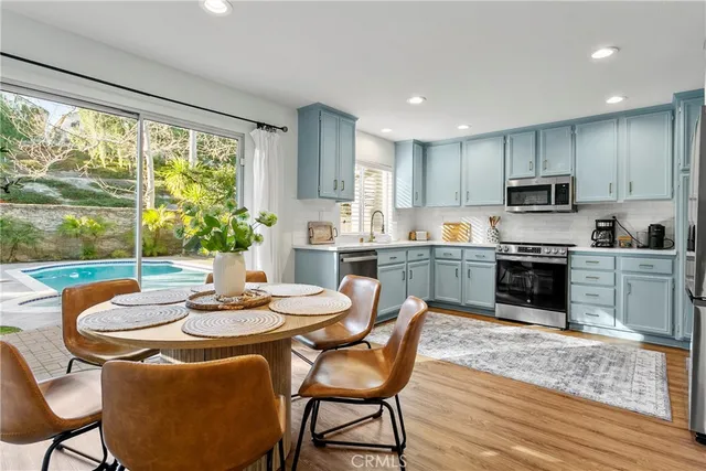a kitchen with a table chairs sink and cabinets