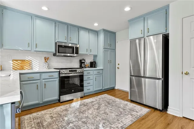 a kitchen with granite countertop a refrigerator stove and microwave