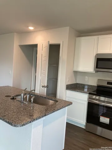 a kitchen with stainless steel appliances granite countertop a sink stove and microwave
