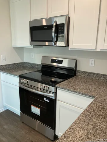 a kitchen with stainless steel appliances granite countertop a stove microwave and sink