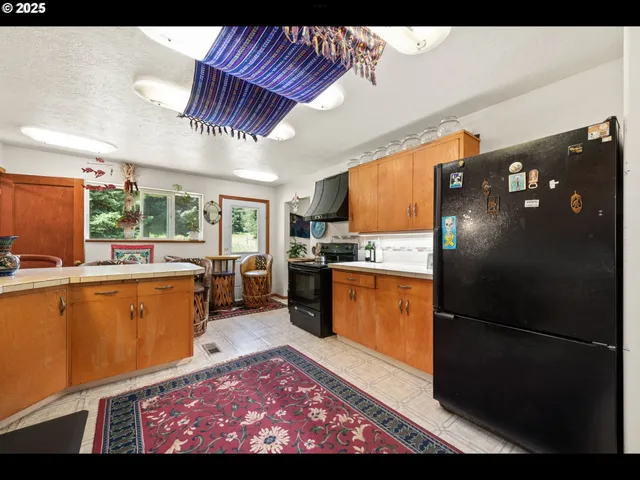 a kitchen with stainless steel appliances granite countertop a refrigerator a sink and a stove