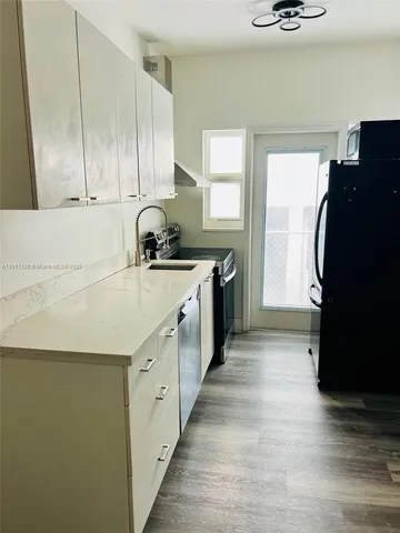 a kitchen with a sink a refrigerator and cabinets