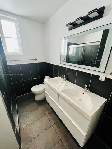 a bathroom with a sink a toilet and mirror