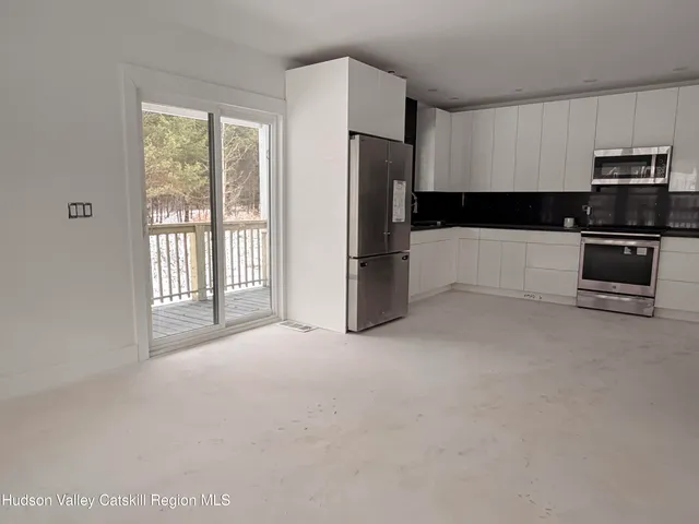 a view of kitchen with stainless steel appliances kitchen island a refrigerator and a stove top oven