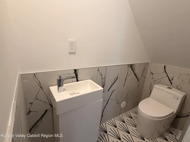 a white toilet sitting next to a bathroom sink