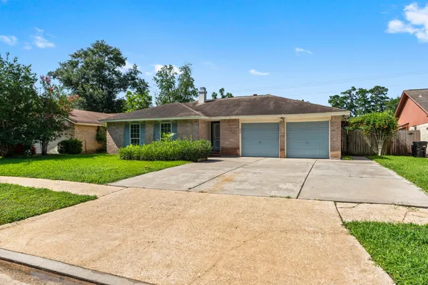 a front view of a house with a yard and potted plants