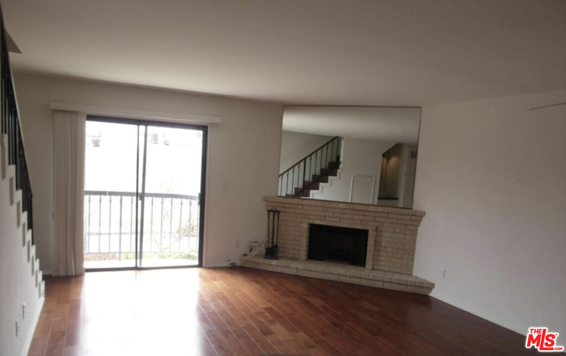 2480 Penmar Avenue, Unit 2 Venice, CA 90291 - Photo 2 of 8 an empty room with wooden floor fireplace and windows