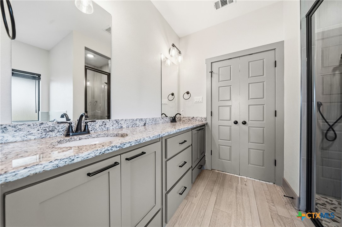 2892 Beulah Boulevard Belton, TX 76513 - Photo 16 of 47 a bathroom with a granite countertop sink mirror and double