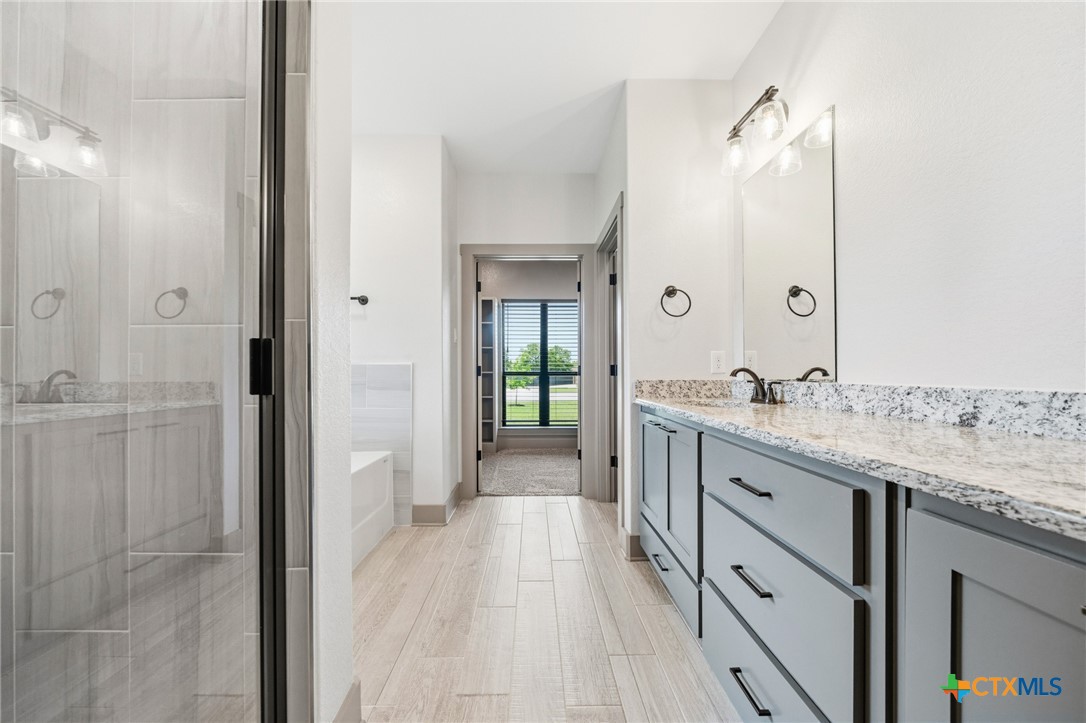 2892 Beulah Boulevard Belton, TX 76513 - Photo 18 of 47 a spacious bathroom with a granite countertop sink mirror and shower
