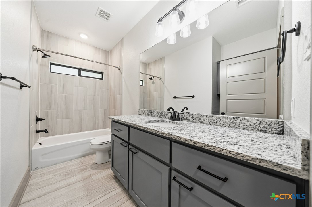 2892 Beulah Boulevard Belton, TX 76513 - Photo 23 of 47 a bathroom with a granite countertop sink a toilet and shower