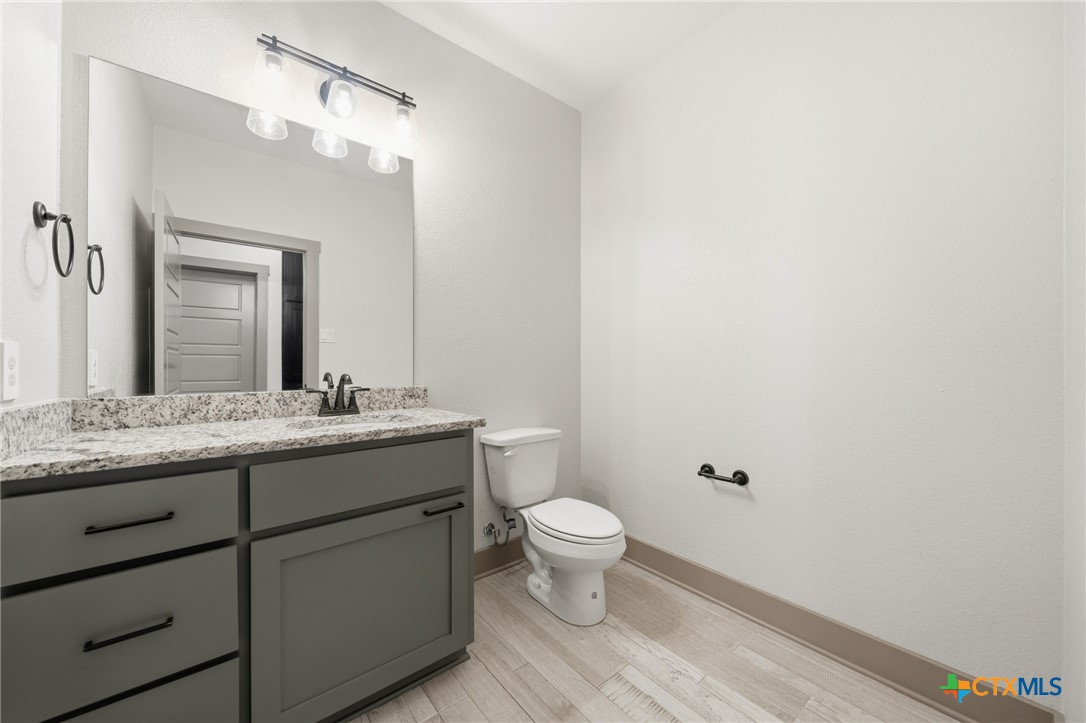 2892 Beulah Boulevard Belton, TX 76513 - Photo 27 of 47 a bathroom with a granite countertop sink mirror and toilet