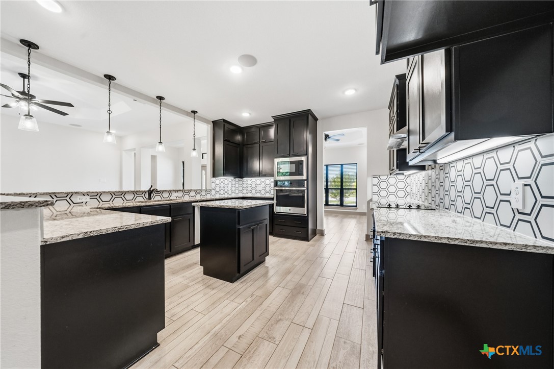 2892 Beulah Boulevard Belton, TX 76513 - Photo 8 of 47 a large kitchen with stainless steel appliances kitchen island granite countertop a sink and cabinets