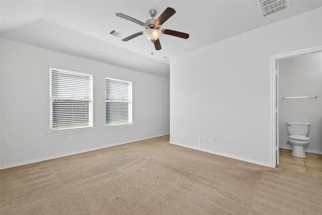 a view of a big room with windows and chandelier fan